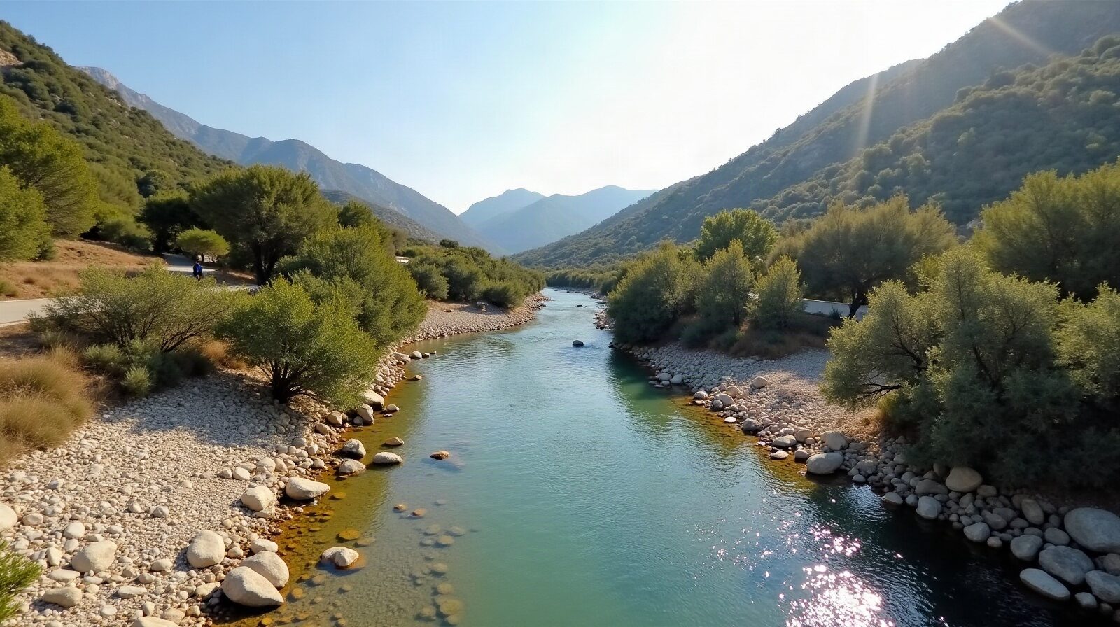 Lit asséché d'un vallon méditerranéen sous la Sainte-Victoire, pierres blanches, chênes verts et sentier de randonnée qui remonte la pente